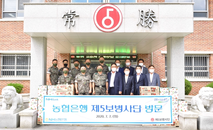 농협은행 농업·공공금융부문 지준섭 부행장(첫줄 왼쪽에서 네 번째)와 직원들이 7일 경기도 연천에 위치한 육군 제5보병사단(열쇠부대)을 방문해 이상철 사단장(첫줄 왼쪽에서 3번째) 및 부대 장병들과 함께 기념촬영을 하고 있다. _농협은행 제공