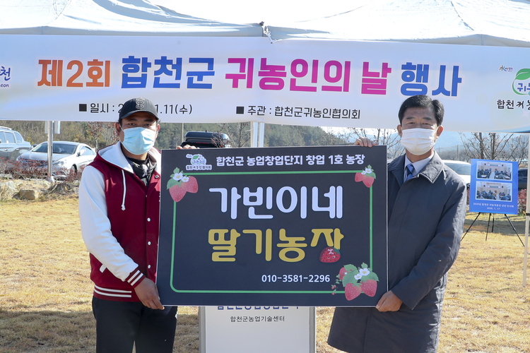 11일 합천군 용주면 합천군농업창엄단지에서 '귀농인의 날 화합 행사'가 열렸다. 사진은 농업창업단지 입교생 중 대구에서 귀농한 김기덕 씨의 딸기농장을 창업 1호 농장으로 선정해 농장 현판을 전달하는 장면(사진: 합천군청).