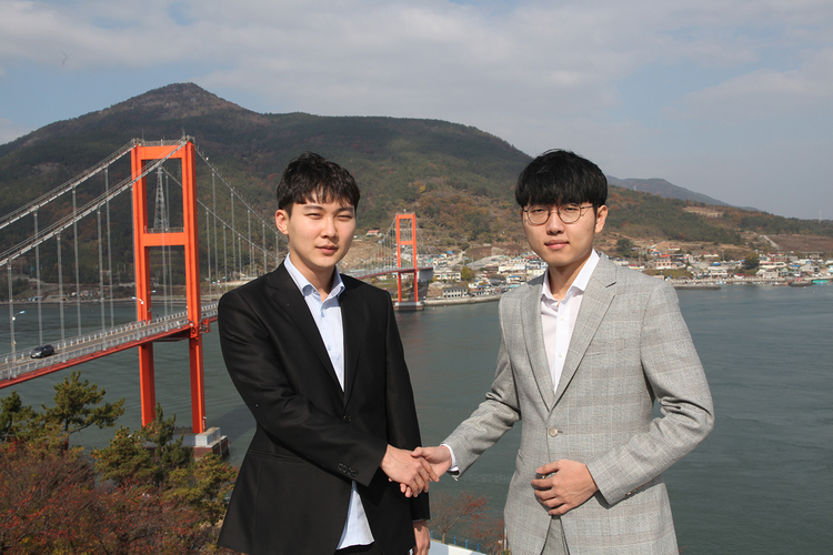한편 시범운영 마지막 날인 12월 1일에는 한국바둑을 대표하는 두 기사, 박정환 9단(왼쪽)과 신진서 9단(오른쪽)이 남해의 절경을 배경으로 펼치는 <아름다운 보물섬 남해 신진서 vs 박정환 바둑 슈퍼매치> 7번기 제6국이 설리스카이워크에서 열린다. 사진은 남해대교를 배경으로 남해각에서 선전을 다짐하며 악수를 나누는 두 기사(사진제공: 한국기원).
