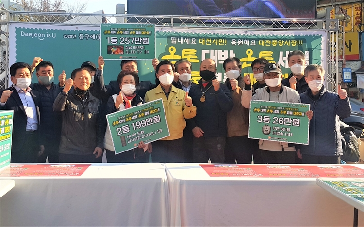 중앙시장 화월통 입구에서 진행된 '동구애(愛) 써유~ 온통세일' 중앙시장활성화구역 경품 추첨행사에 참석한 황인호 동구청장(앞줄 가운데 노란색 점퍼)과 상인회장들 (제공 : 대전 동구청) 