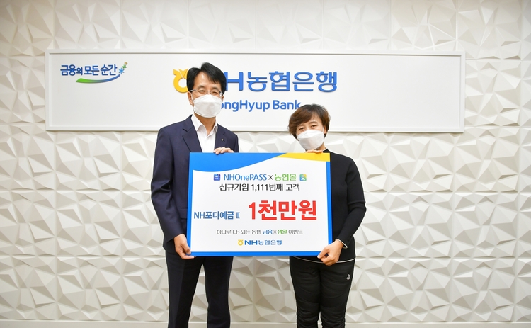 지난 11일 서울 중구 농협은행 본점에서 농협은행 손병환 은행장(왼쪽)과 이벤트 1,111번째 응모 고객이 1천만원 정기예금 증서를 들고 기념촬영을 하고 있다.