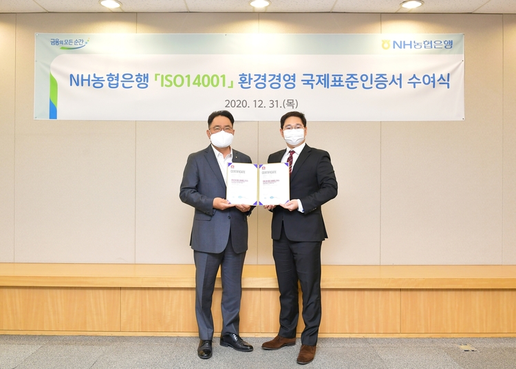 지난 12월 31일 서울시 중구에 위치한 농협은행 본점에서 NH농협은행 지준섭 농업·녹색금융부문 부행장(왼쪽)과 로열서트코리아 이권상 대표(오른쪽)가 ISO 14001 인증서 수여식을 갖고 기념촬영을 하고 있다(사진: NH농협은행).