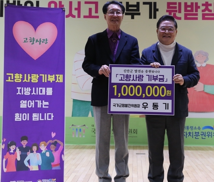 우동기 국가균형발전위원장(우)이 신안군에 100만원 고향사랑 기부금을 냈다. (사진_신안군 제공)