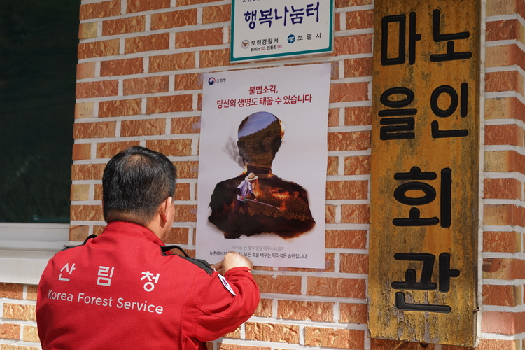 산불 방지를 위해 홍보 포스터를 마을 회관에 부착하고 있다. _ 사진 : 산림청 제공 